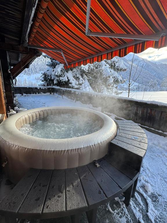 a hot tub on a wooden deck in the snow at Sunny Mountain in Reckingen - Gluringen