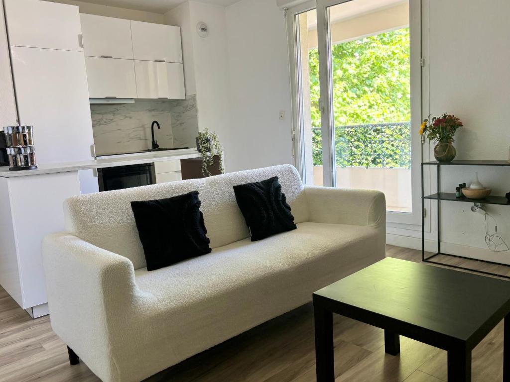 un salon avec un canapé blanc et une table dans l'établissement Appartement T3 Avignon, proche centre-ville, à Avignon