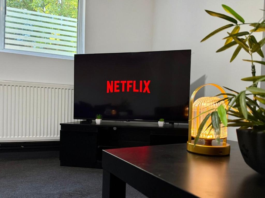 a television with a netflix sign on a table at Cosy King Size Escape - Free Parking in Birmingham