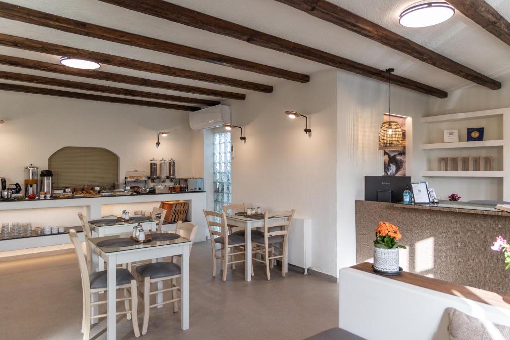 um restaurante com mesas e cadeiras em uma sala em Hotel Rigas em Adamas