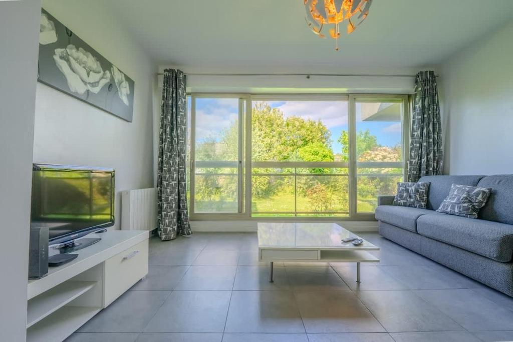 un salon avec un canapé et une télévision dans l'établissement Studio - L'Ancre Grise, à La Rochelle