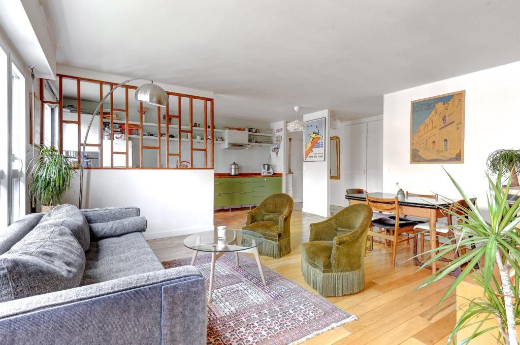 un salon avec un canapé, des chaises et une table dans l'établissement Magnifique Appartement avec vue sur Tour Eiffel avec 3 chambres, à Paris