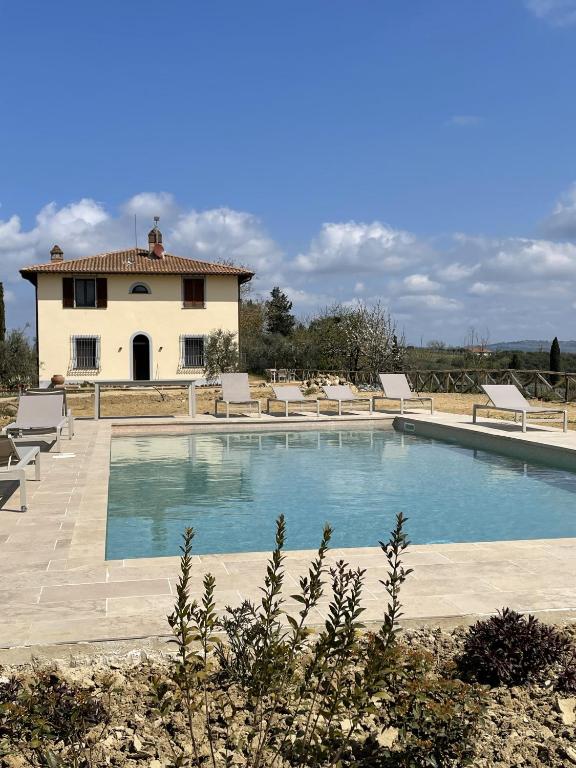 a pool with chairs and a house in the background at Dolce Villa Toscana - private pool, air conditioning in San Gimignano