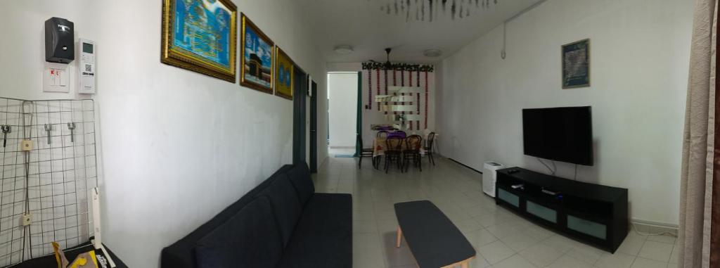 a living room with a couch and a flat screen tv at MAM Guesthouse Kota Tinggi in Kota Tinggi