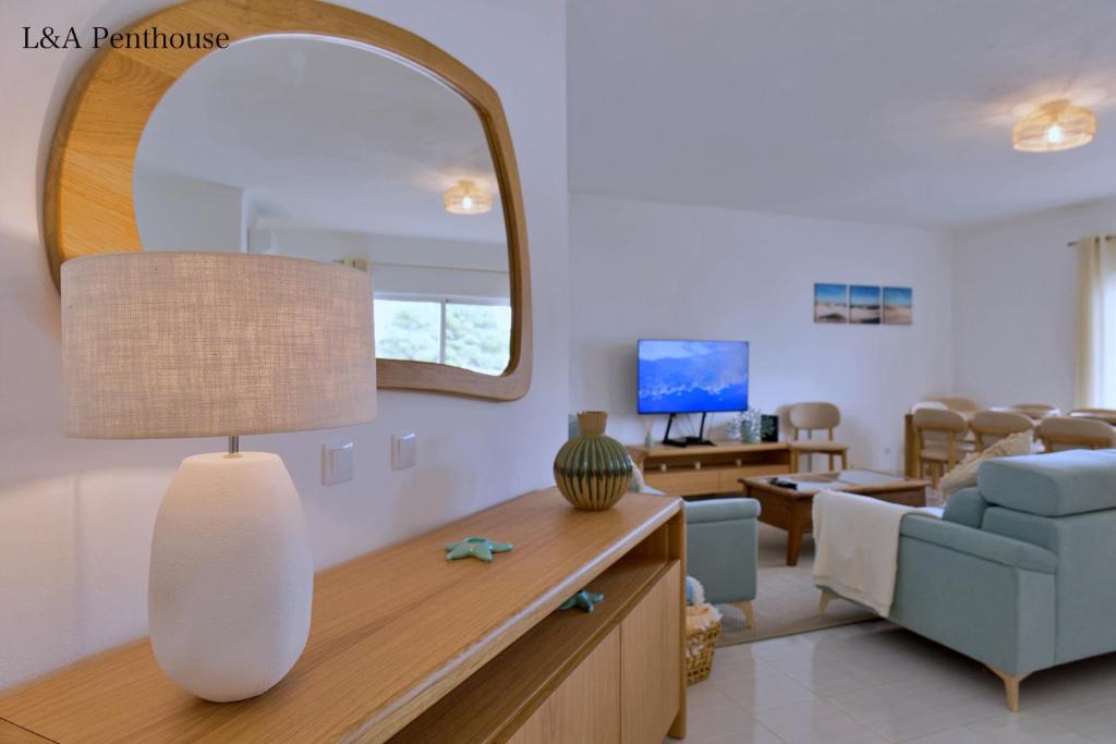 un soggiorno con un grande specchio e un divano di Penthouse L&A Prainha with sea view, 2 Terraces ad Alvor