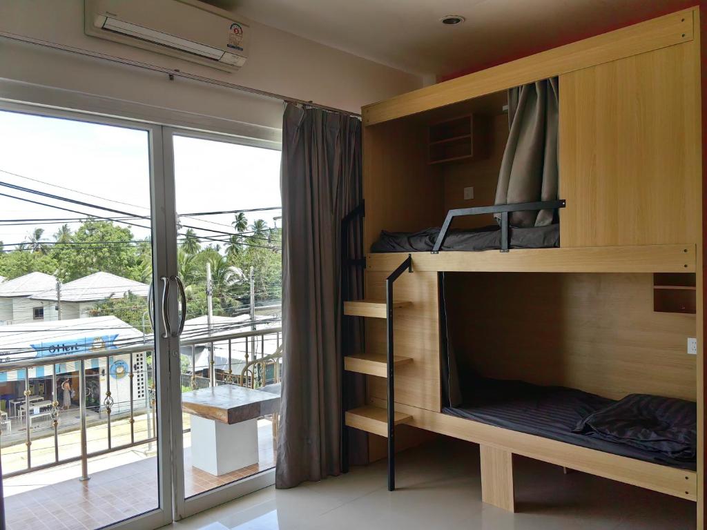 a room with bunk beds and a large window at Arena Seaview in Baan Tai