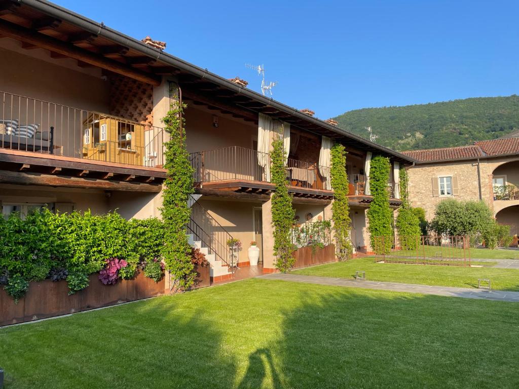 ein Gebäude mit einem grünen Hof davor in der Unterkunft La Maison in Franciacorta in Colombaro