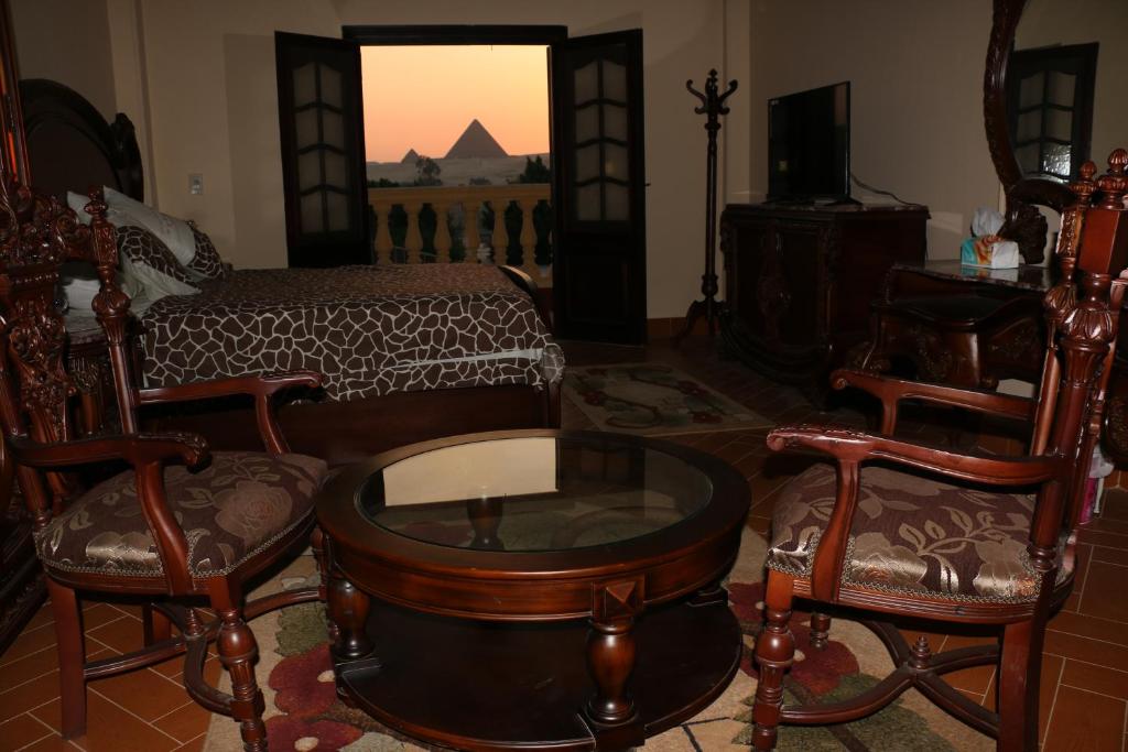sala de estar con cama, mesa y sillas en Pyramids Power Inn en El Cairo