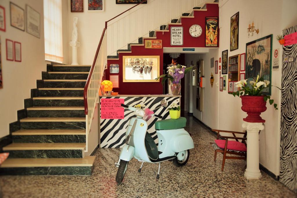 una moto estacionada en un pasillo junto a una escalera en Hotel Villa Elia en Rímini