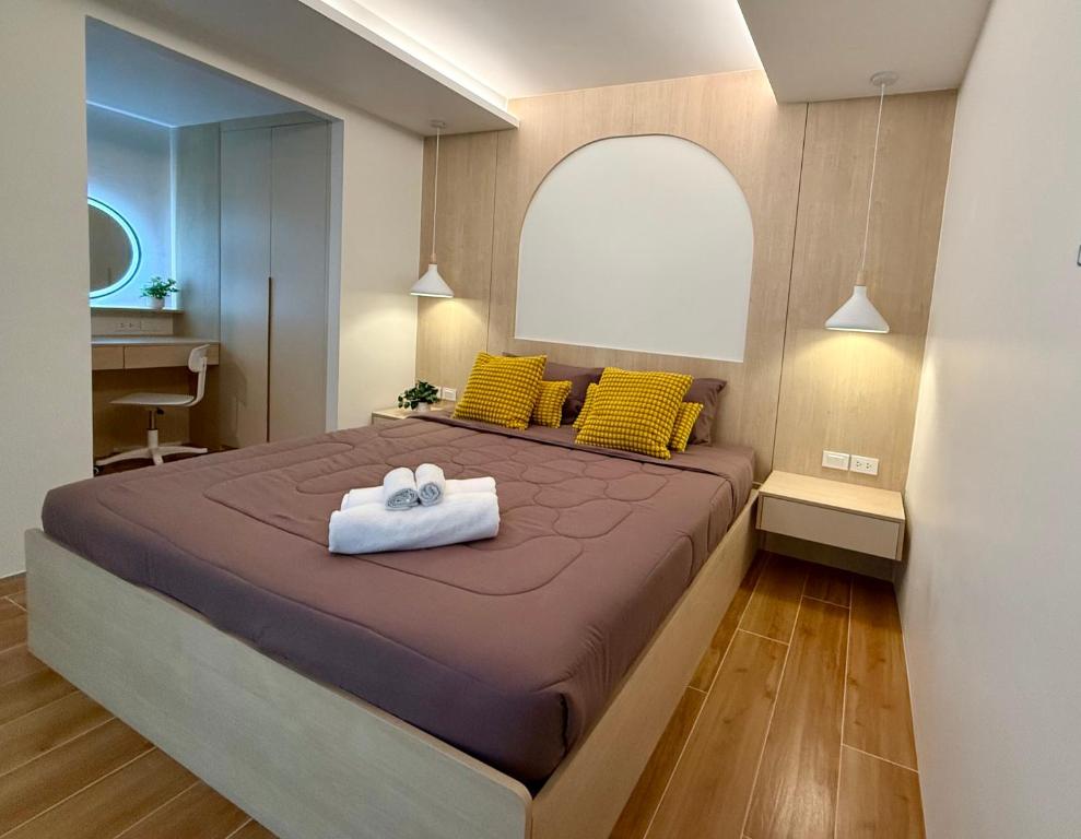 a bedroom with a large bed with yellow pillows at Fantasea Kamala Beach 1 BR 313 in Kamala Beach