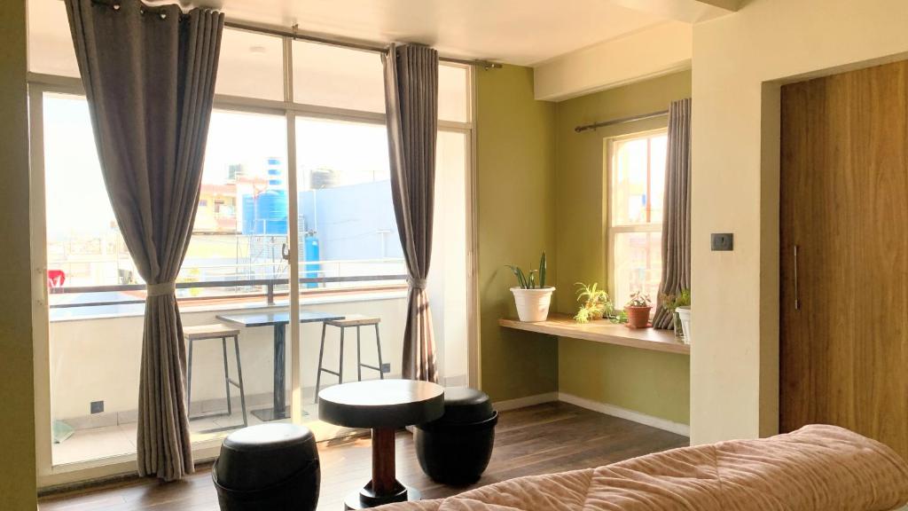 a living room with a large window and a table at Lavish Stay at Boudha, Kathmandu, Heuju Residence in Kathmandu