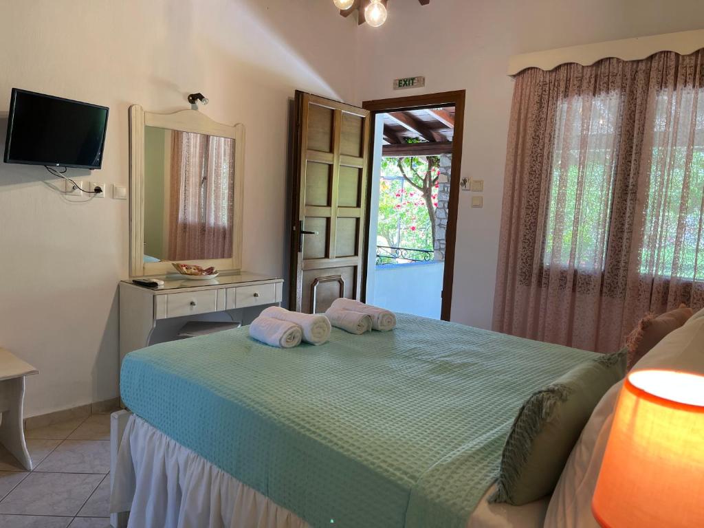 a bedroom with a bed with two pillows on it at Maniatis Garden in Achladies