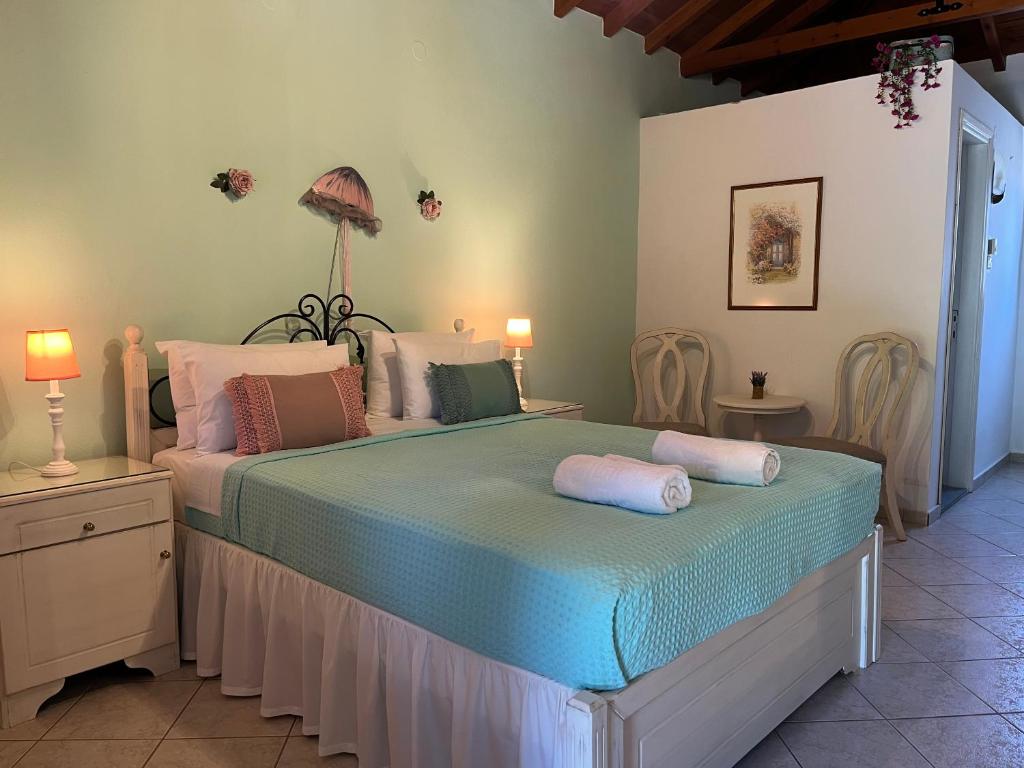 a bedroom with a bed with pillows on it at Maniatis Garden in Achladies