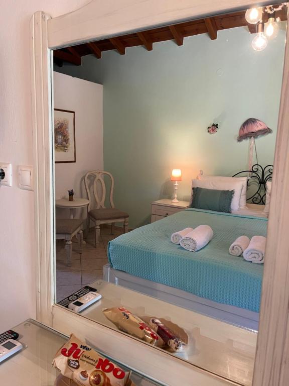 a bedroom with a bed and a mirror at Maniatis Garden in Achladies