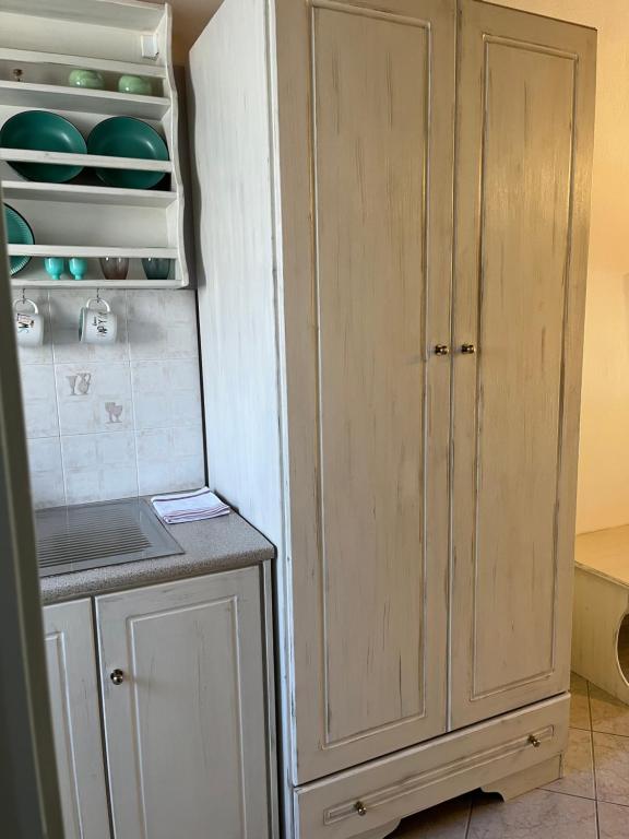 a kitchen with a white cabinet next to a counter at Maniatis Garden in Achladies