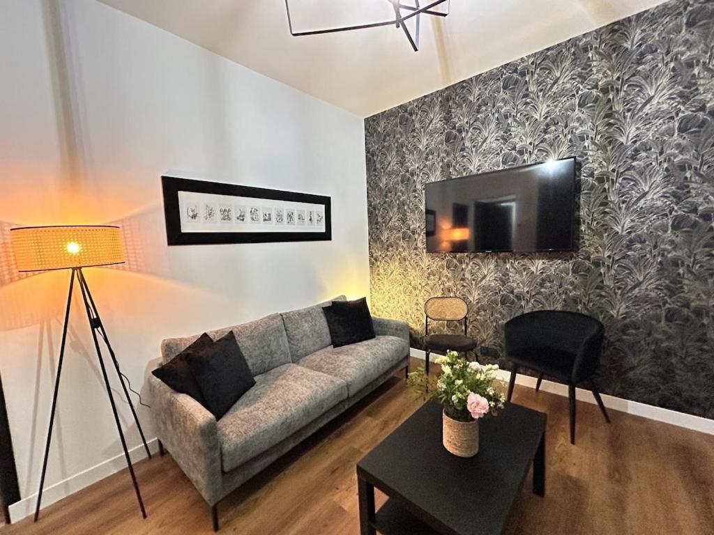 un salon avec un canapé et une télévision sur un mur dans l'établissement Laon Magnifique T3 à deux pas du centre-ville, à Reims