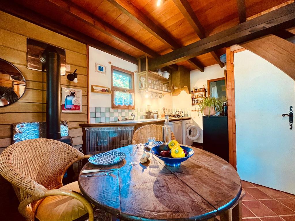 a kitchen with a wooden table with a bowl of fruit on it at Le Perce Neige in Durbans