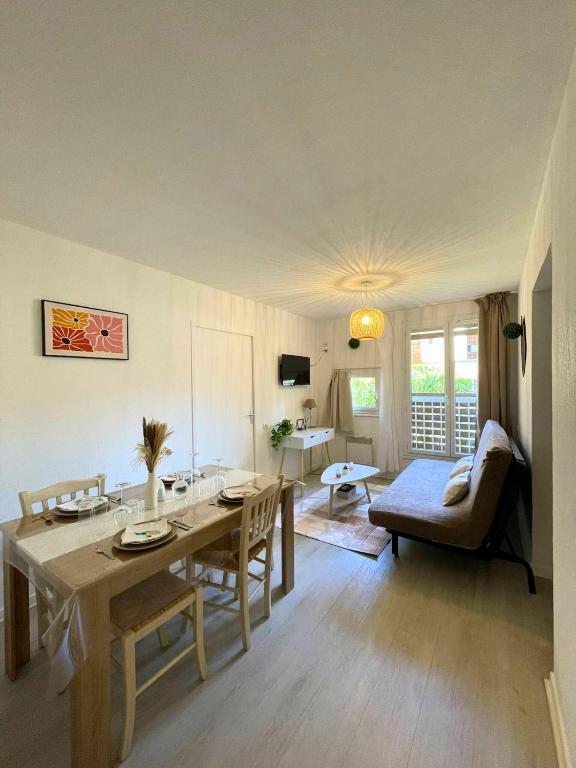 - un salon avec une table à manger et un canapé dans l'établissement Le Havre Doré Ile d'Or Vacancéole Residence, à La Londe-les-Maures
