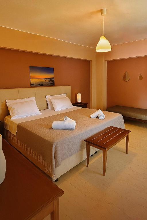 a bedroom with a large bed and a table at Villa Fotini in Syvota
