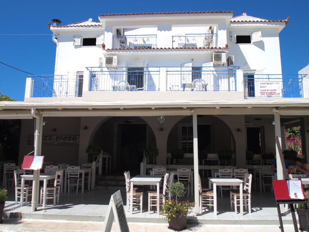 un edificio bianco con tavoli e sedie di fronte di Ionion Apartments a Skala di Cefalonia