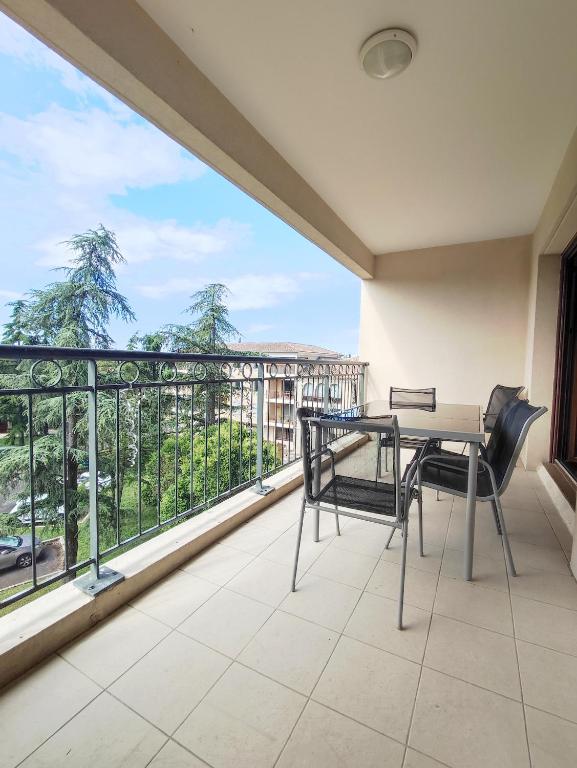 un balcon avec une table et des chaises et une grande fenêtre dans l'établissement Appartement avec grande terrasse au centre ville d'Uzès, à Uzès