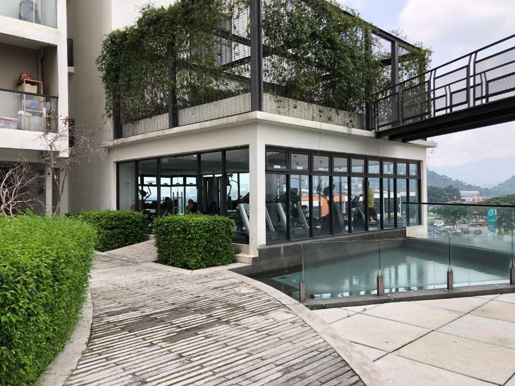 a building with a pool in front of it at Modern Escape Urban 360 by LUVIT STAY in Batu Caves