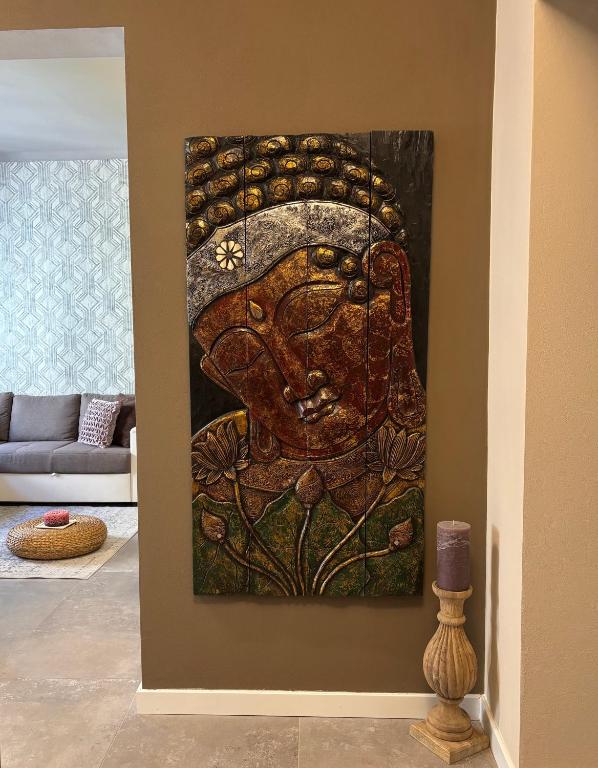 a painting of a head on a wall in a living room at Samsara Apartment in Pienza