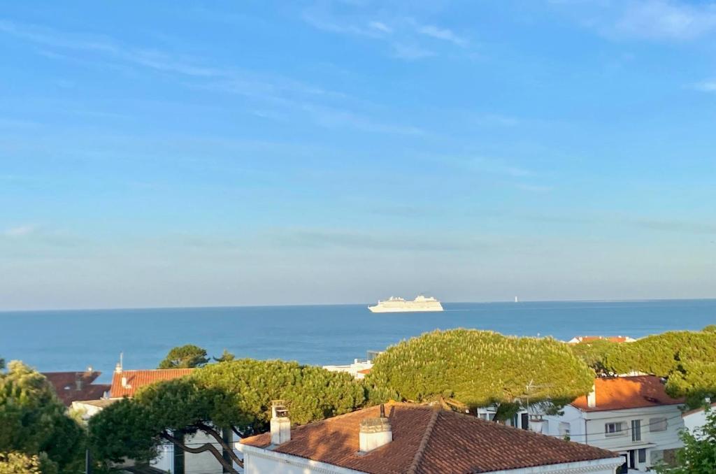 un navire de croisière dans l'océan avec une ville dans l'établissement Trois Plages Pleine Mer, à Royan