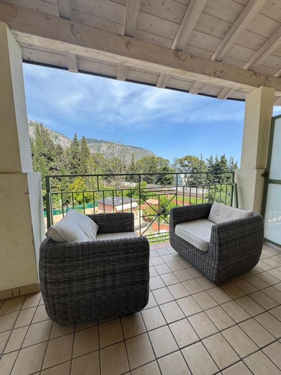- deux chaises en osier assises sur une terrasse avec vue dans l'établissement Apartment duplex in Eze sur Mer, à Èze