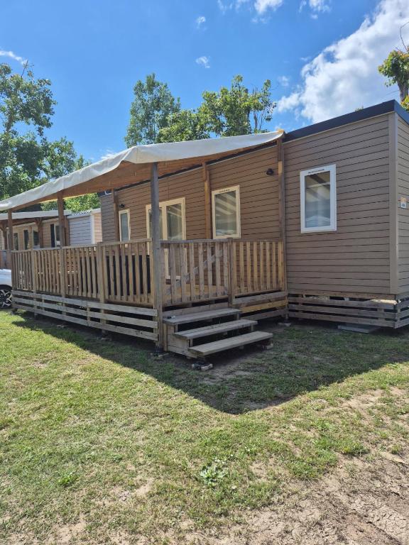 une maison modulaire avec un porche et des escaliers sur une cour dans l'établissement Mobilhome 6 personnes domaine de la yole, à Vendres