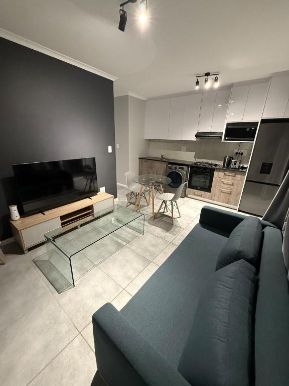 a living room with a couch and a glass table at Table Mountain View Apartment in Cape Town