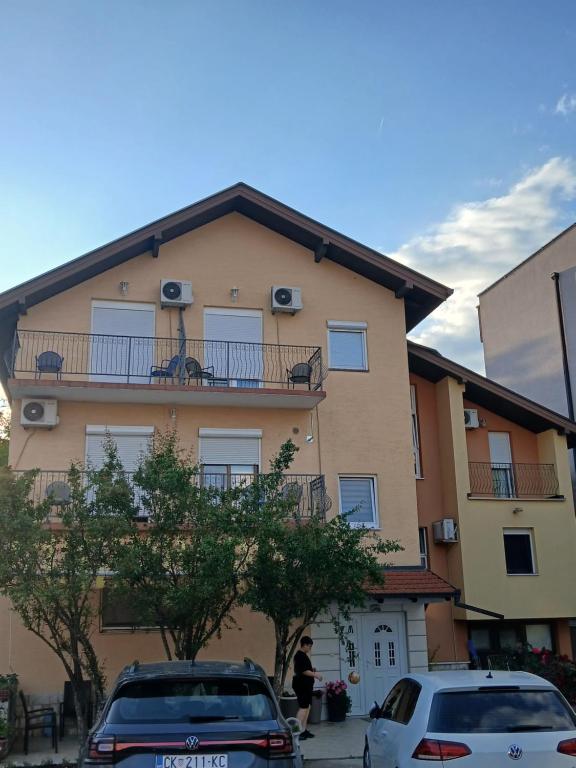 ein Gebäude mit zwei davor geparkten Autos in der Unterkunft N i N in Međugorje