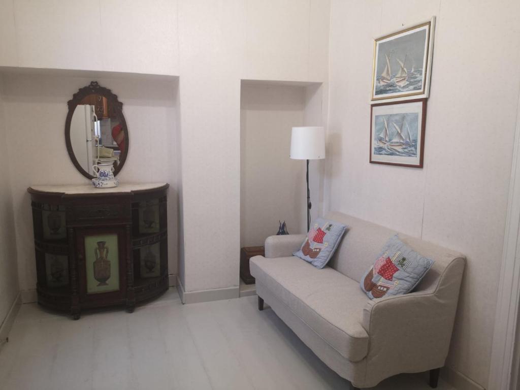 a living room with a couch and a mirror at Pitsi House Plomari in Plomarion