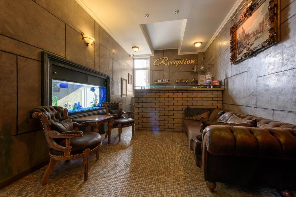 una sala de espera con sofás de cuero y TV en Premium Hotel en Chernivtsi