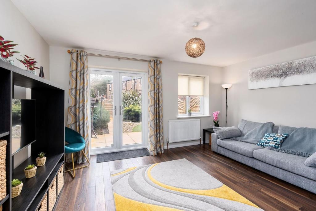 a living room with a couch and a tv at Stunning 3 Bedroom Home Hillsborough Sheffield in Sheffield