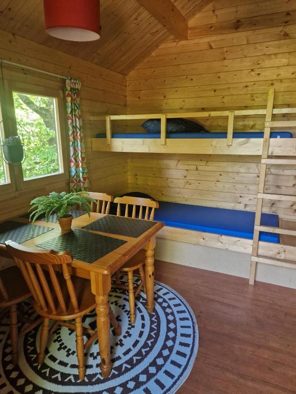 een eetkamer met een tafel en een stapelbed bij Camping Alkenhaer Appelscha Blokhut Basic in Appelscha