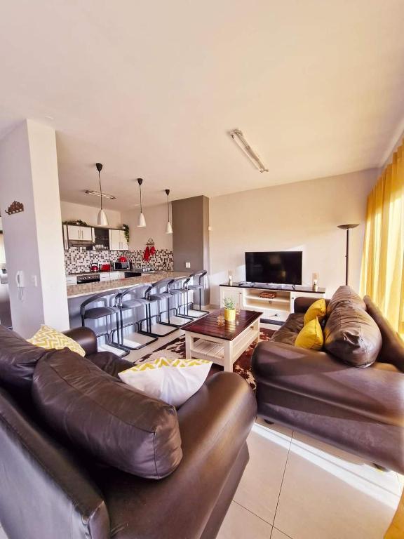 a living room with leather couches and a television at 6 on Sunset Valley in Khomas Region