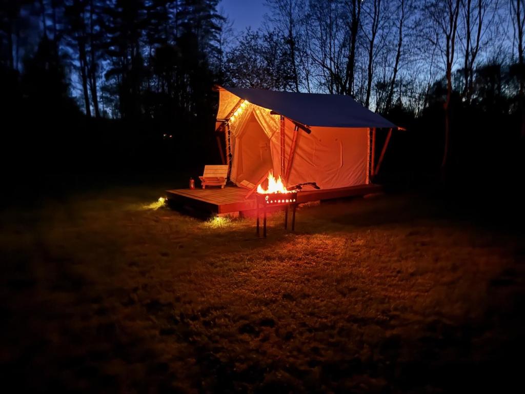 a tent with a fire in a field at night at Salmiņu kempings - Camping in Pastva Barbern