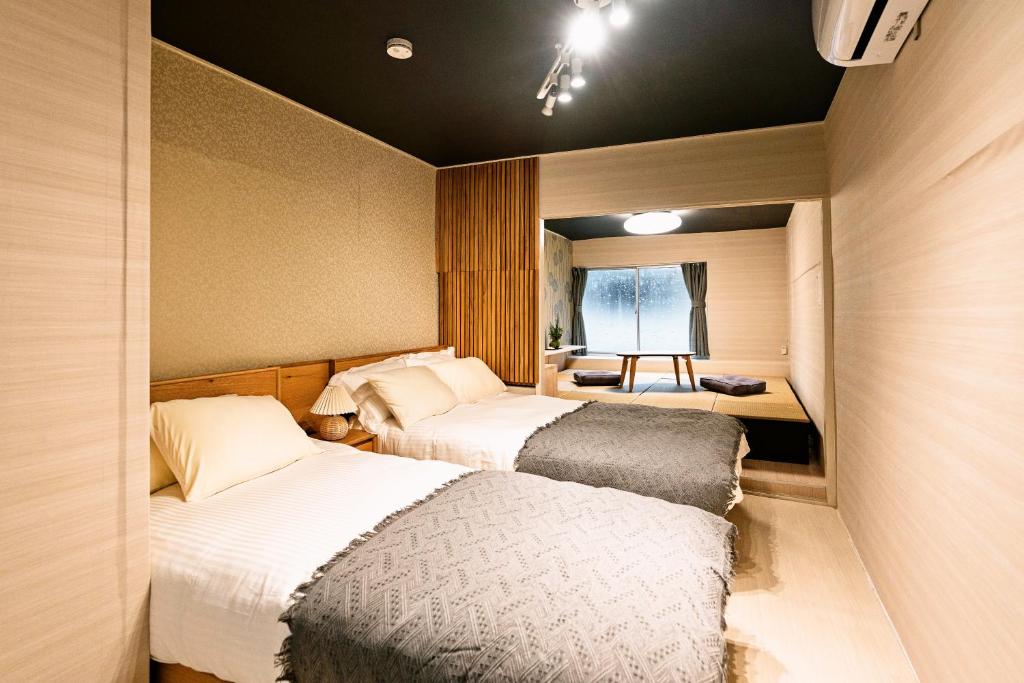大阪市にあるSUIMEI Ebisuの窓のある小さな部屋にベッドが2つある