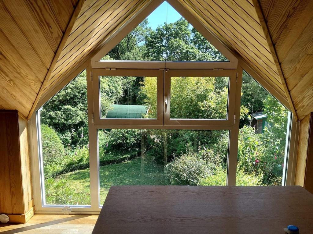 a large window in a pavilion with a view of a garden at Maison de charme dans un environnement exceptionnel in Vannes