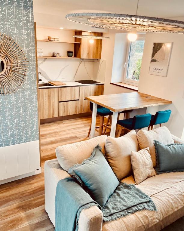 un salon avec un canapé et une cuisine dans l'établissement La cabane des plages, à Plouescat