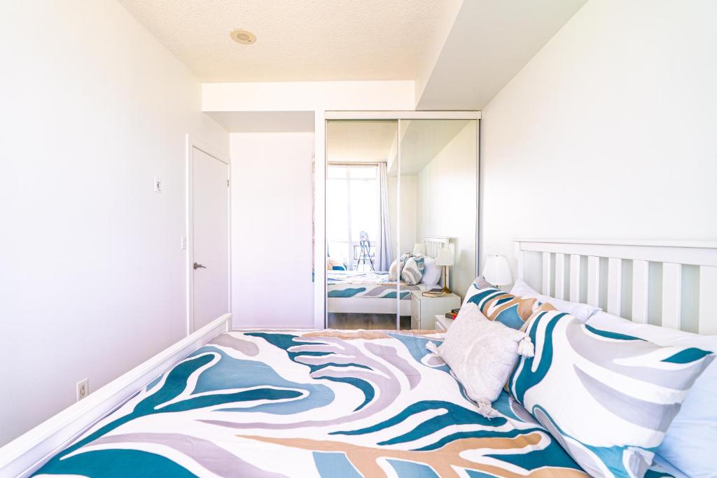 a bedroom with a bed with a large mirror at 1BD Plus Den Lakeview Suite - Steps to CN Tower & Rogers Centre - Free Parking in Toronto