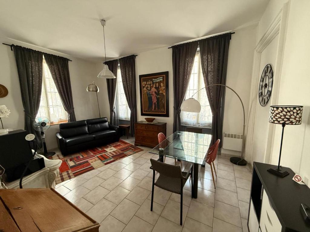 - un salon avec un canapé noir et une table en verre dans l'établissement Appartement RDC avec parking en intra-muros, à Avignon