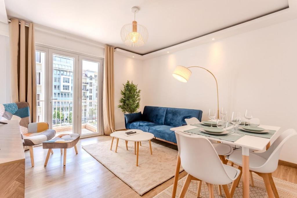 un salon avec un canapé bleu et une table dans l'établissement Nice Appartement 4pers à 2 pas de la promenade, à Nice