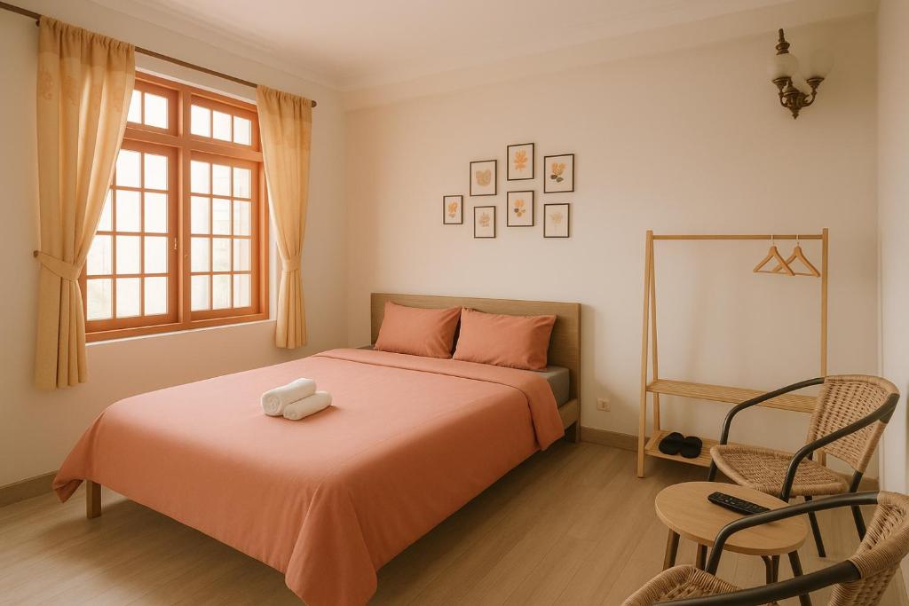a bedroom with a bed and a window and a chair at Happy House Homestay in Hue