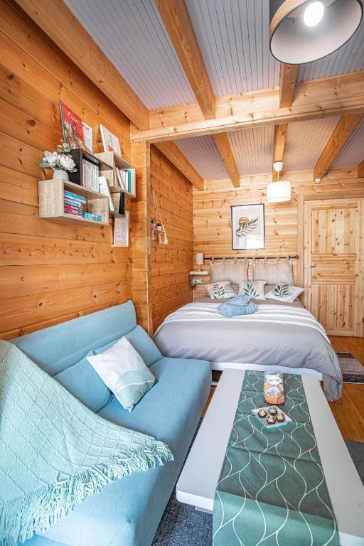 un salon avec deux lits et un canapé dans l'établissement Ambiance Bois & Charme Proche Lyon, à Saint-Genis-les-Ollières