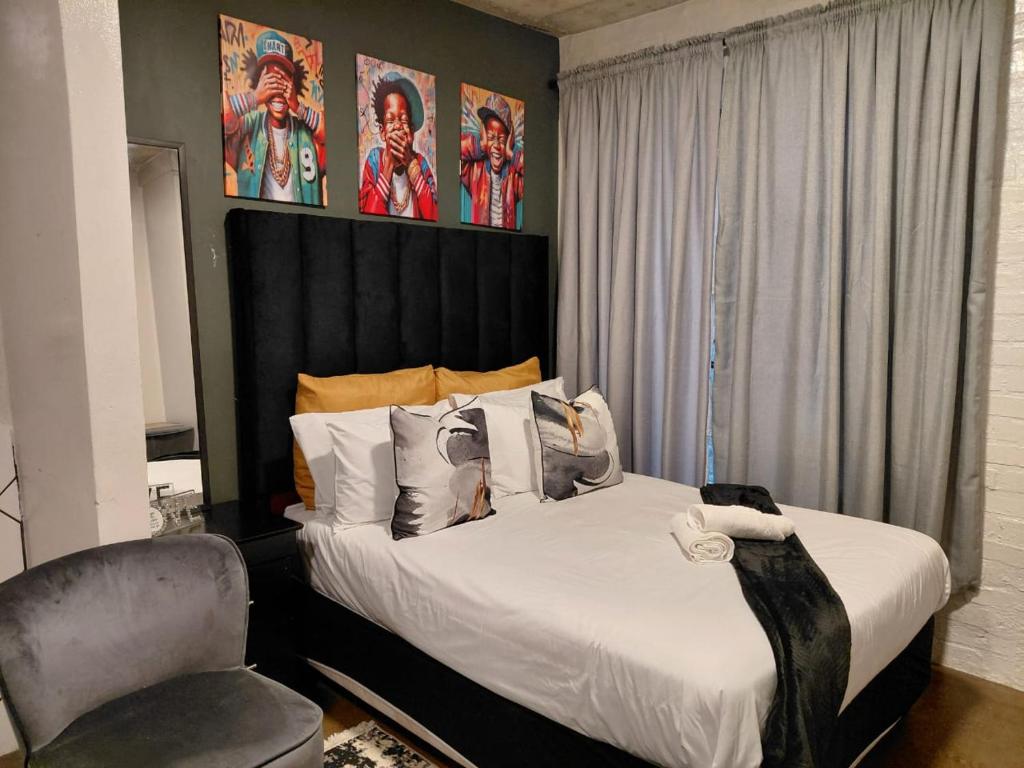 a bedroom with a bed and a chair at Cosy 103 City Building apartment in Maboneng, with free wifi in Johannesburg