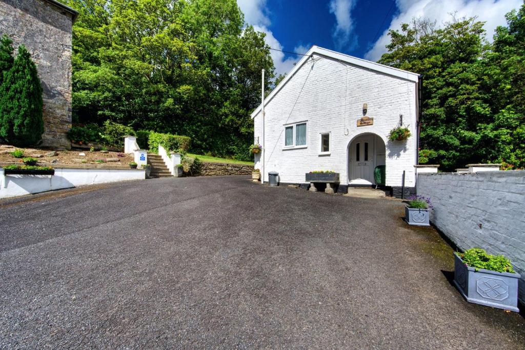 un vialetto vuoto di fronte a un edificio bianco di Upcott Cottage a Barnstaple