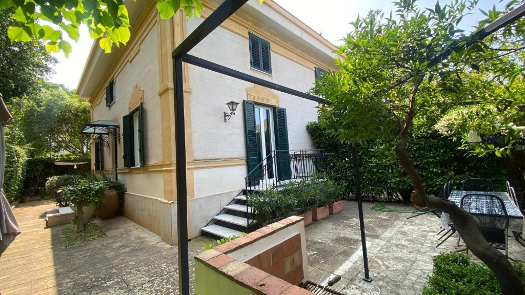 an outside view of a building with a stairway to a door at Villa Pola Liberty house Mondello in Palermo