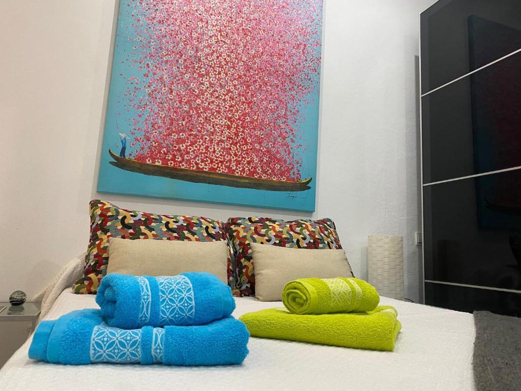 a room with two pillows on a bed with a painting at Escapada junto a Picasso in Málaga